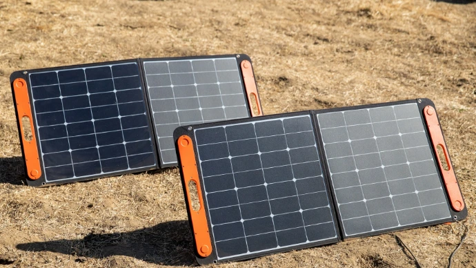 a couple of black and orange rectangular objects on a dirt surface